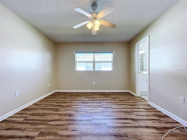 spare room featuring ceiling fan, wood-type flooring, and a textured ceiling