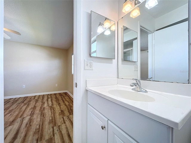 bathroom featuring a textured ceiling, wood-type flooring, and vanity