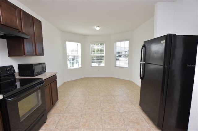 kitchen with light tile patterned floors, dark brown cabinets, and black appliances