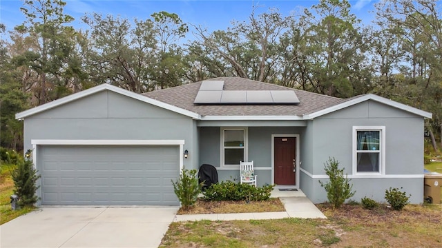 view of front of property with a garage and solar panels