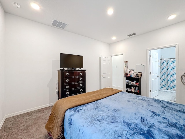 bedroom with light colored carpet and ensuite bathroom