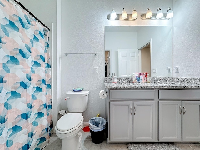 bathroom featuring curtained shower, tile patterned floors, vanity, and toilet