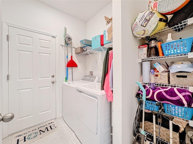 laundry area with light tile patterned floors and washing machine and clothes dryer