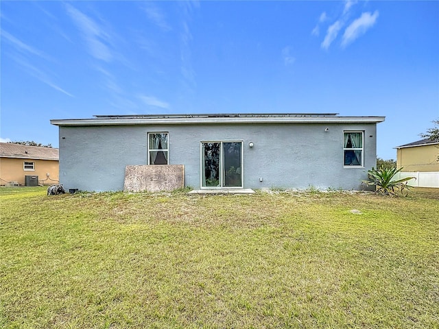 rear view of property with a lawn and cooling unit