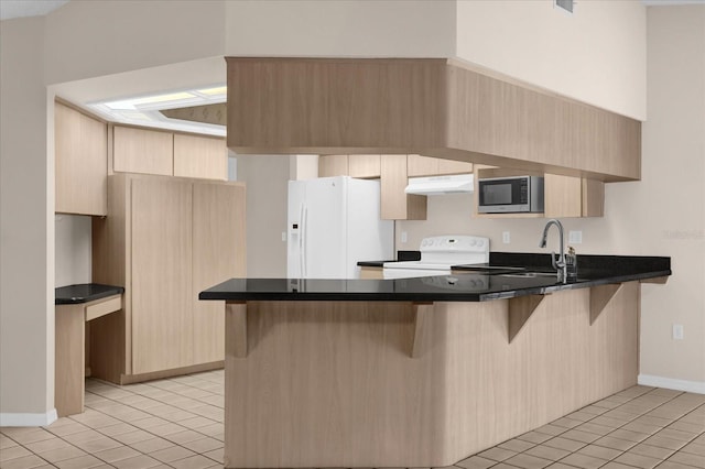 kitchen featuring stainless steel microwave, kitchen peninsula, range with electric cooktop, and white refrigerator with ice dispenser