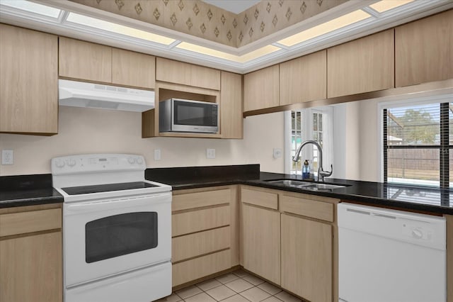 kitchen with kitchen peninsula, sink, white appliances, light brown cabinets, and light tile patterned floors