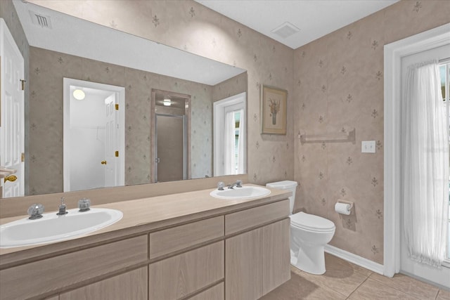 bathroom featuring walk in shower, vanity, tile patterned flooring, and plenty of natural light