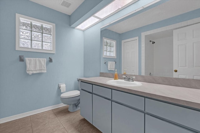 bathroom featuring toilet, vanity, and tile patterned flooring