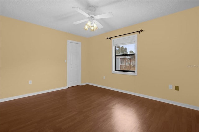 spare room featuring ceiling fan, dark hardwood / wood-style floors, and a textured ceiling