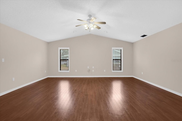 spare room featuring vaulted ceiling, ceiling fan, a healthy amount of sunlight, and wood-type flooring