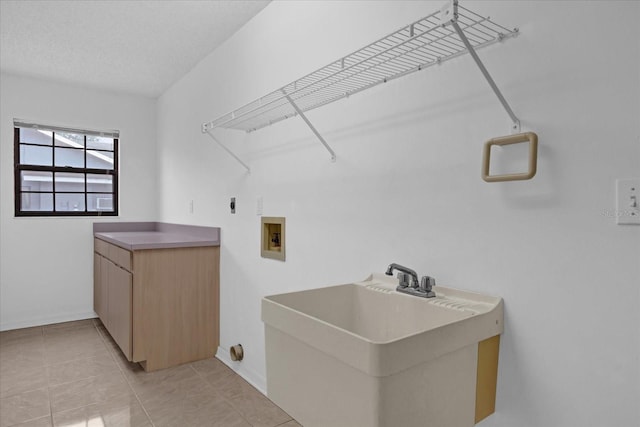 laundry room with sink, light tile patterned flooring, hookup for a washing machine, a textured ceiling, and hookup for an electric dryer