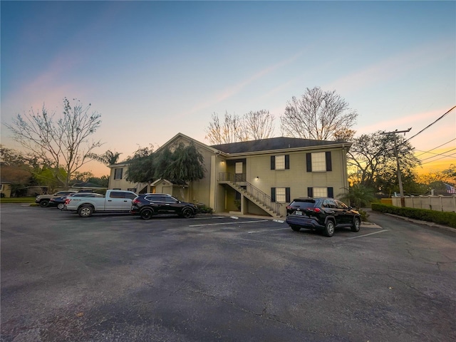 view of property with uncovered parking and stairway