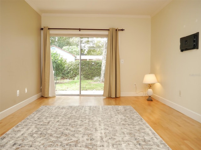 unfurnished room featuring baseboards, ornamental molding, and wood finished floors