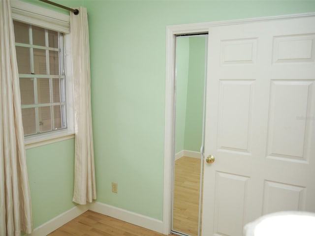 unfurnished bedroom featuring a closet, baseboards, and wood finished floors