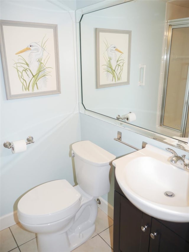 bathroom featuring toilet, vanity, baseboards, and tile patterned floors