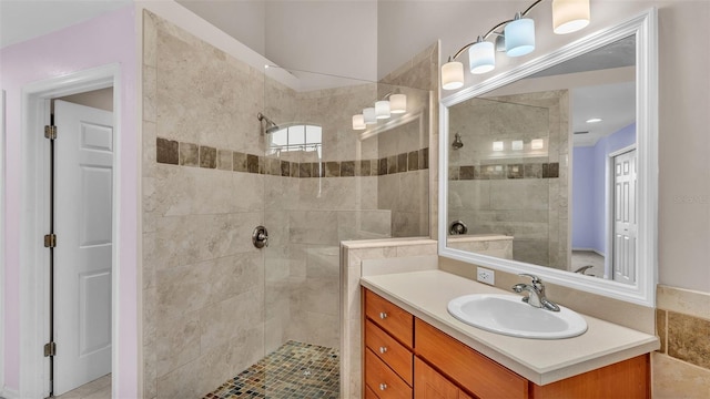 bathroom featuring tiled shower and vanity