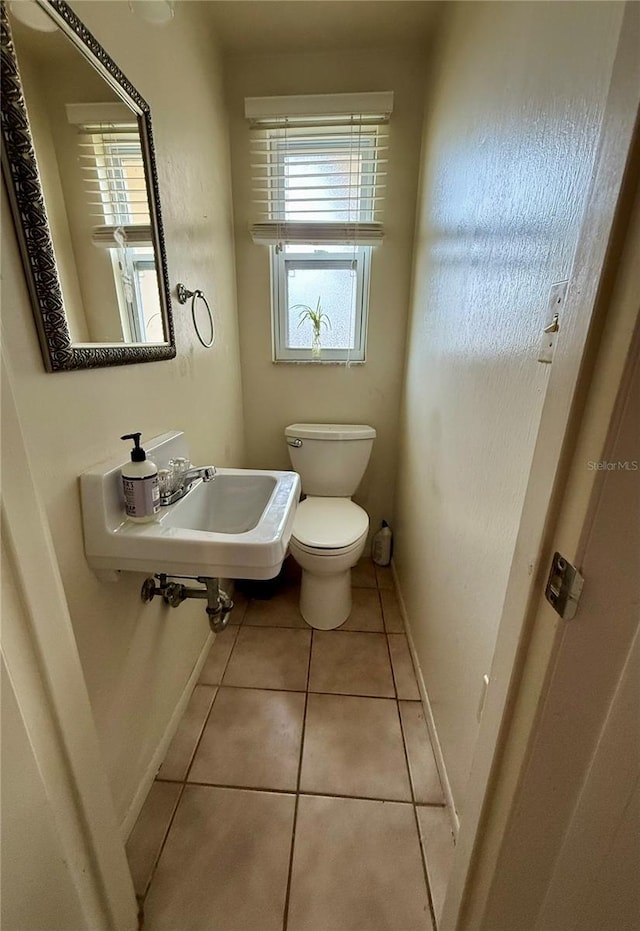 bathroom featuring toilet, tile patterned flooring, and sink