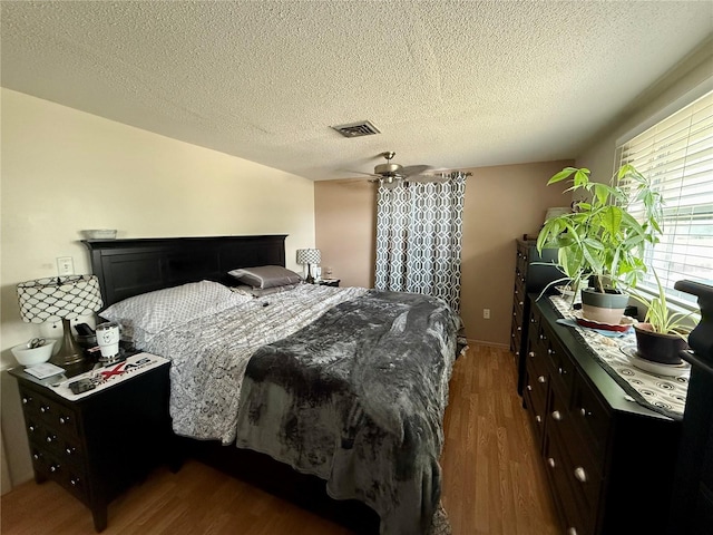 bedroom featuring a textured ceiling and dark hardwood / wood-style floors