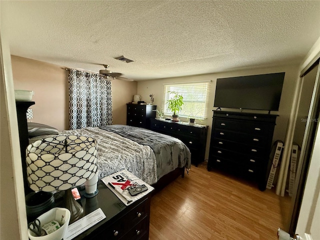 bedroom with a textured ceiling, a closet, and hardwood / wood-style floors