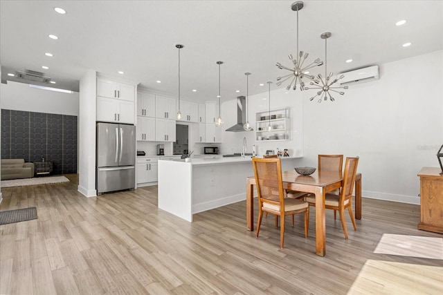 dining space featuring light wood-type flooring, a wall mounted AC, sink, and an inviting chandelier