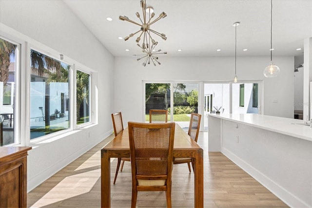 dining area featuring a healthy amount of sunlight, a notable chandelier, and light hardwood / wood-style floors