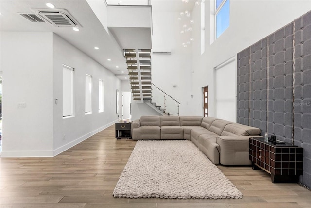 living room with light wood-type flooring and a high ceiling