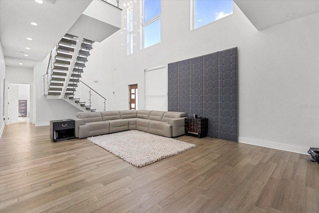 unfurnished living room featuring a towering ceiling and light wood-type flooring