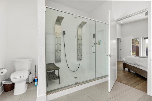 bathroom with a shower with shower door, tile patterned flooring, and toilet