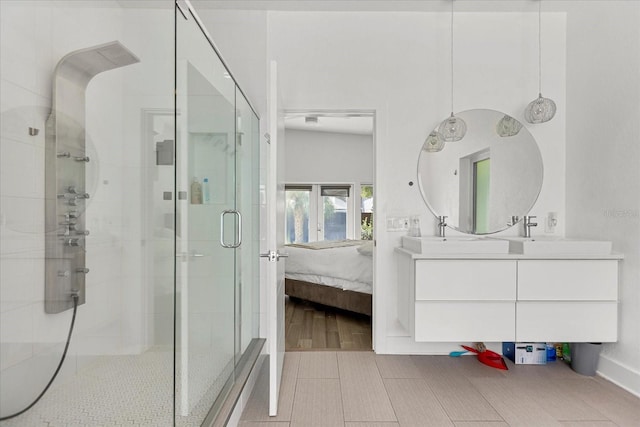 bathroom with a shower with shower door and vanity