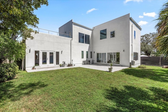 back of house featuring a patio area, french doors, and a lawn