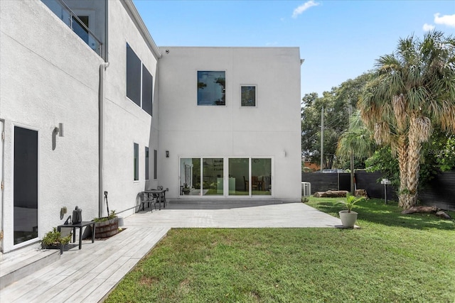 rear view of property featuring a patio area and a lawn