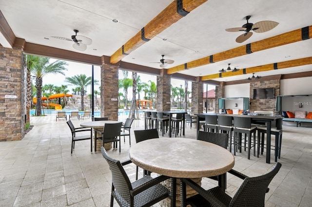 view of patio with ceiling fan, a swimming pool, and exterior bar