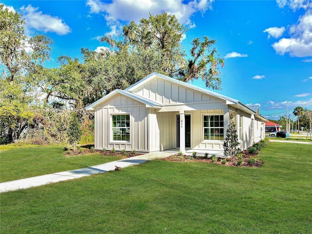 modern inspired farmhouse featuring covered porch and a front yard