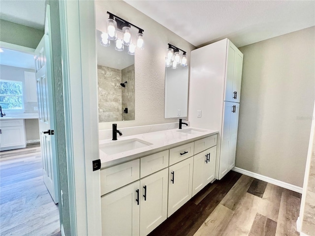 bathroom with a shower, hardwood / wood-style floors, and vanity