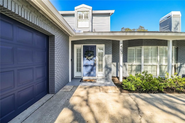 doorway to property with central AC unit and a garage