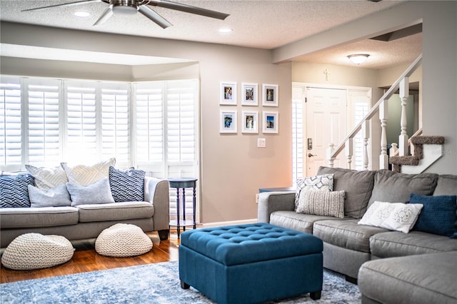 living room featuring ceiling fan, wood-type flooring, and a textured ceiling