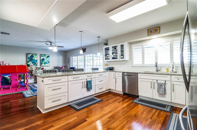 kitchen featuring dark wood-type flooring, white cabinetry, stainless steel appliances, kitchen peninsula, and ceiling fan