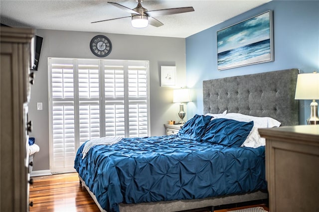 bedroom with ceiling fan, a textured ceiling, and hardwood / wood-style floors