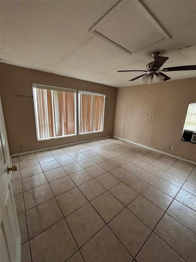 tiled empty room with ceiling fan and plenty of natural light