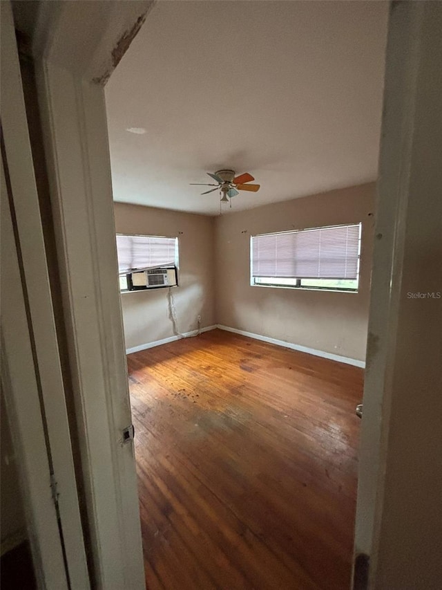 spare room with ceiling fan, cooling unit, and hardwood / wood-style floors