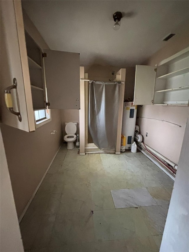 bathroom with toilet, walk in shower, and electric water heater