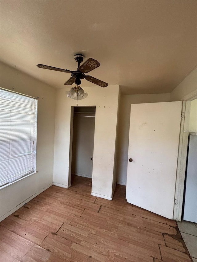 unfurnished bedroom with ceiling fan, a closet, and light hardwood / wood-style flooring