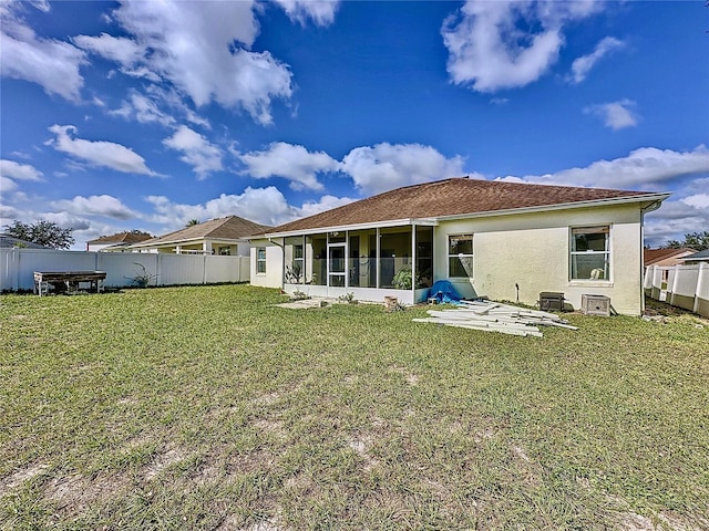 back of house featuring a patio area, a sunroom, and a lawn