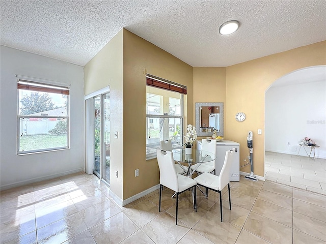 dining space featuring a textured ceiling and light tile patterned floors