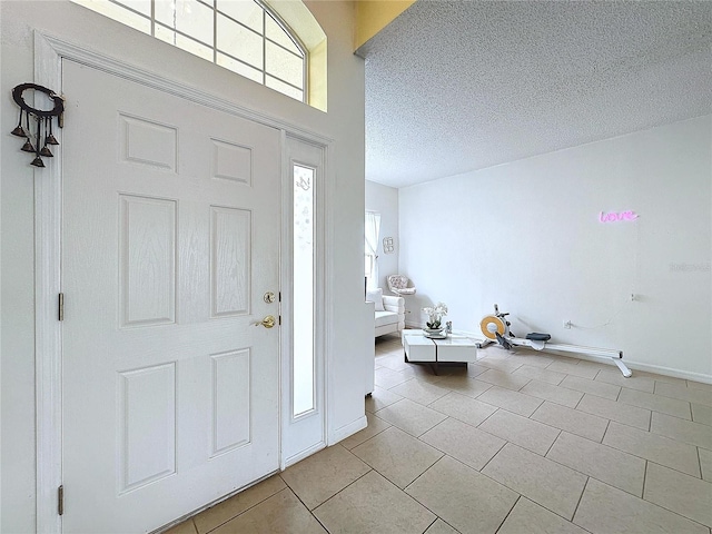 entryway with a textured ceiling and light tile patterned flooring