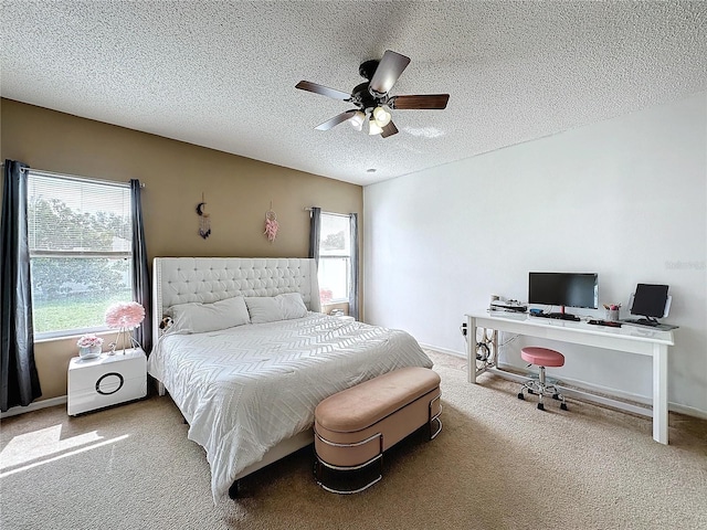 bedroom with ceiling fan, carpet floors, and a textured ceiling