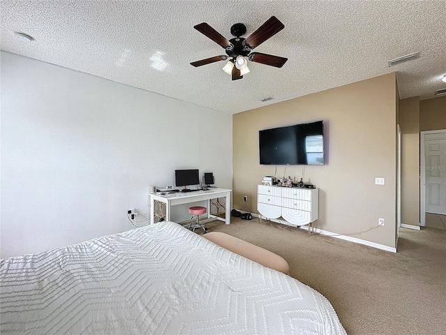 bedroom with ceiling fan, a textured ceiling, and carpet flooring