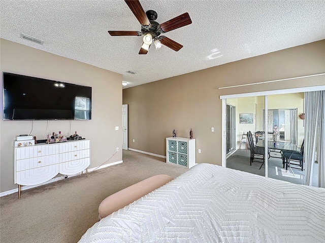 carpeted bedroom featuring ceiling fan, access to exterior, and a textured ceiling