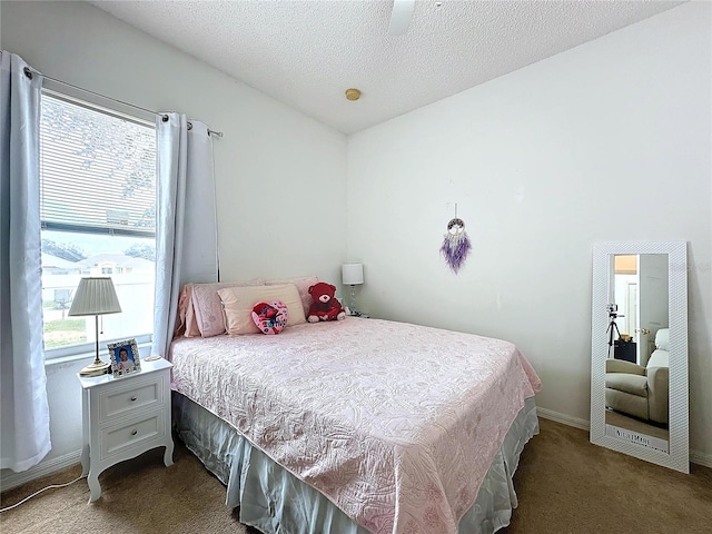 bedroom with ceiling fan, carpet, and a textured ceiling