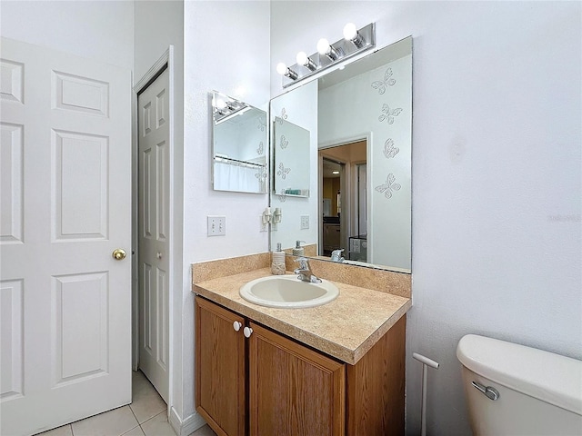 bathroom featuring toilet, vanity, and tile patterned floors